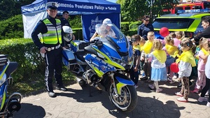 dzieci i policjant przy motocyklach policyjnych.