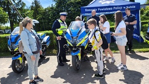 dzieci i policjant przy motocyklach policyjnych.