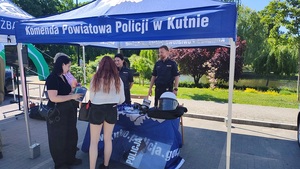 policjanci na stoisku promocyjnym wraz z zainteresowanymi osobami służbą w policji.