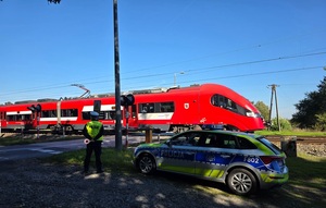 policjant kontrolujący przejazd kolejowy.