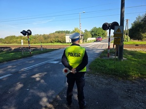 policjant kontrolujący przejazd kolejowy.